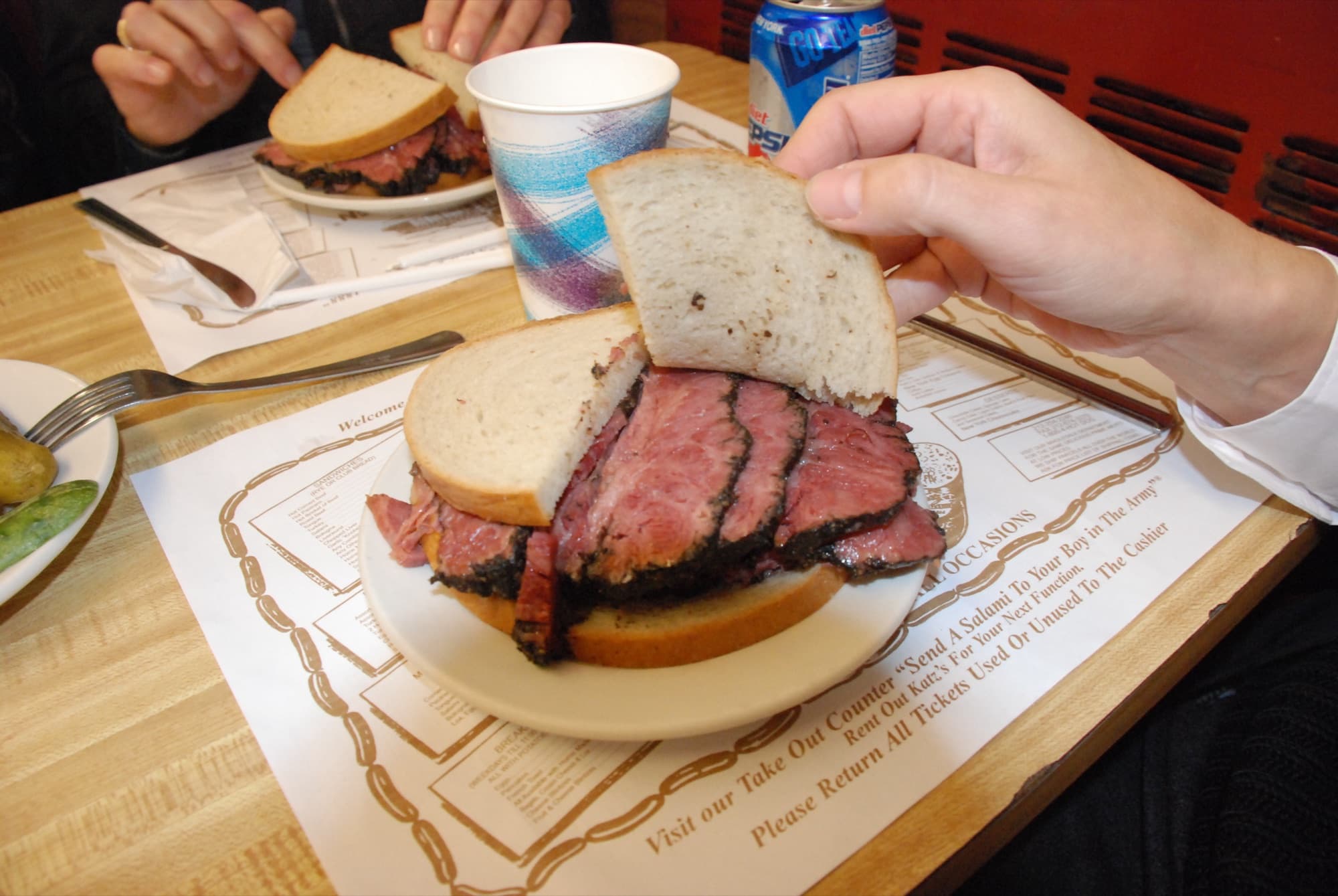 Overflowing New York pastrami deluxe bagel piled with hand-carved pastrami