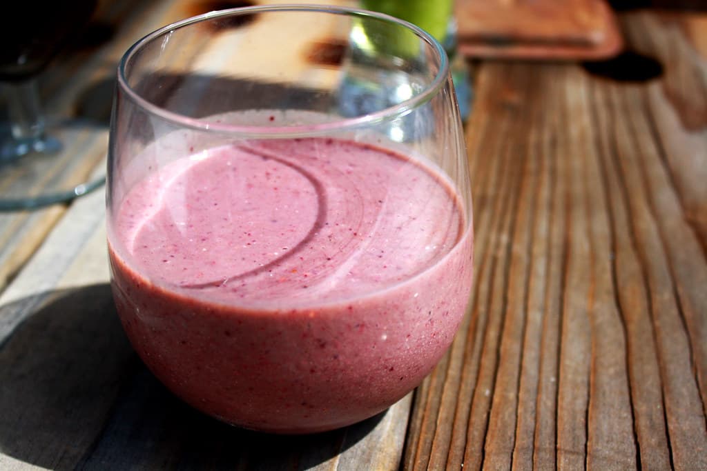 Berry smoothie in a glass on a wooden table