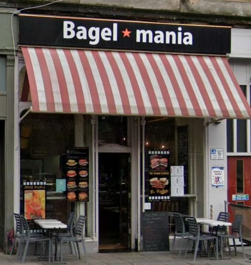 The Bagel Mania shopfront on Byres Road with its red-and-cream striped awning and pavement tables