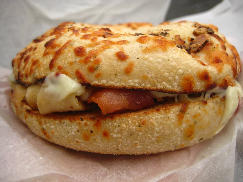 Golden toasted everything bagel with melted cheese oozing from the sides